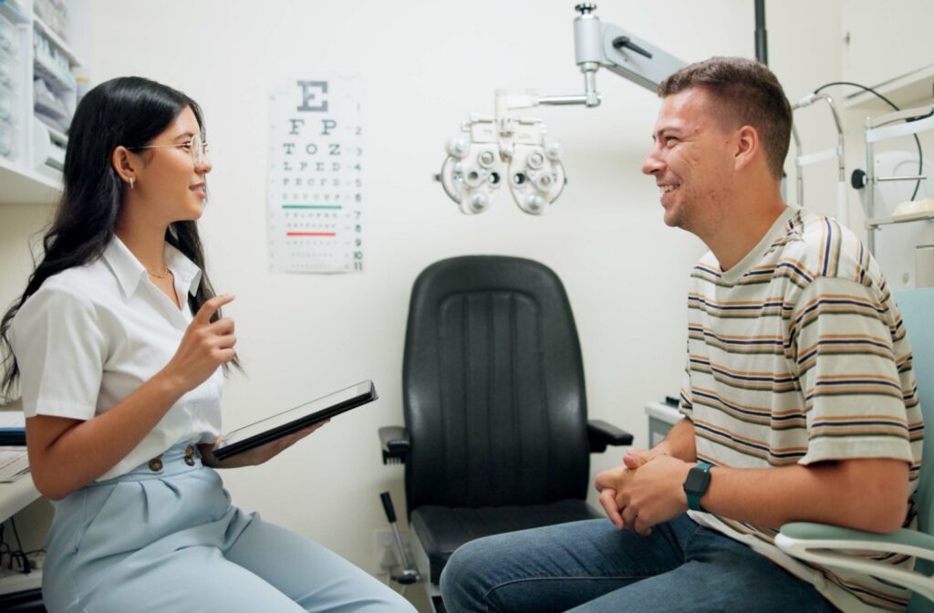 A man talks to his optometrist about low-level light therapy as an option for dry eye disease in her office