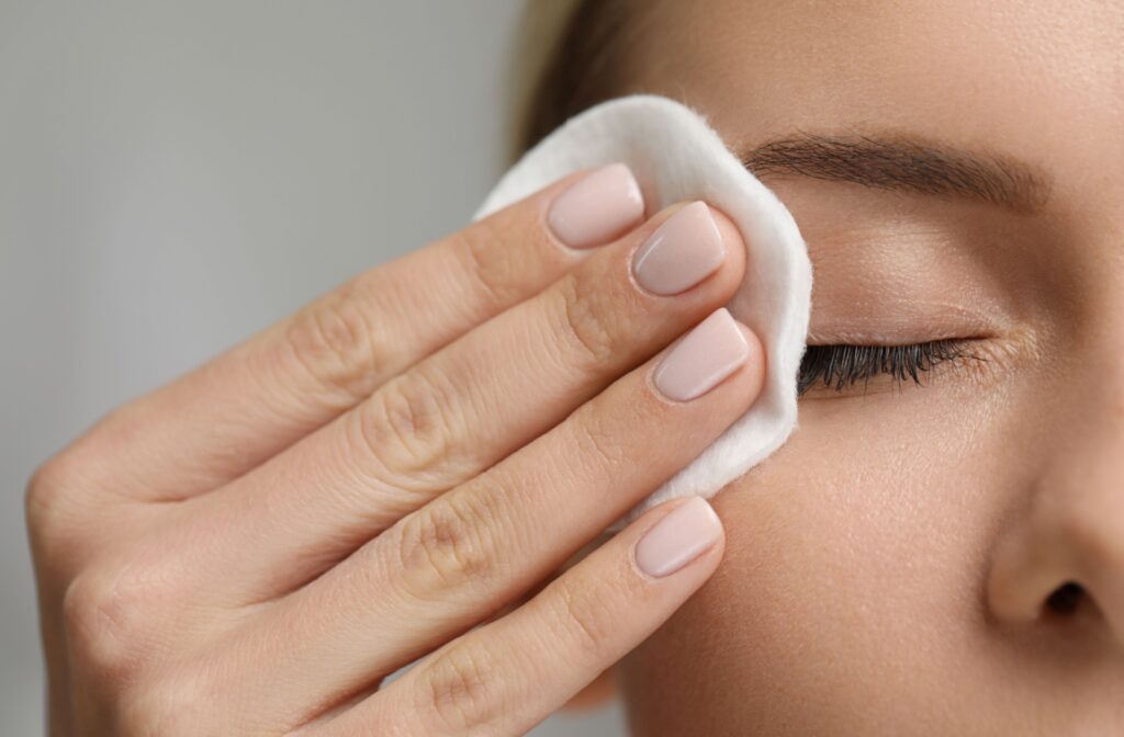 A young person practices good eye hygiene by removing their eye makeup wipe before bed.