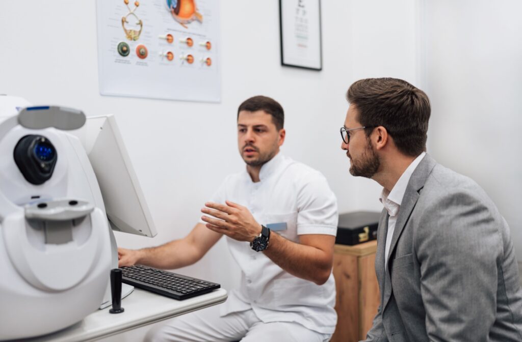 Optometrist explaining eye health to a patient in an exam room.