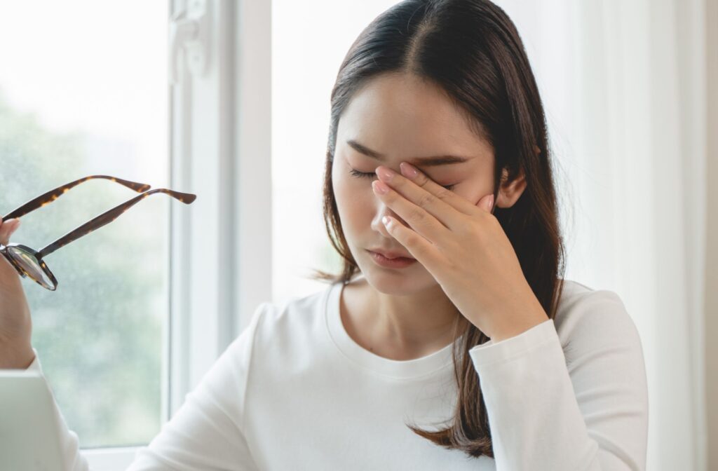 Close-up of a person rubbing their eyes, showing discomfort and signs of dry eye irritation