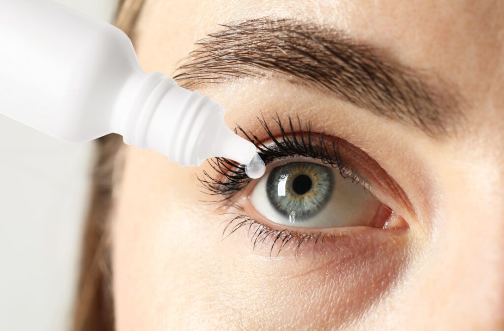 A close up of a person putting eye drops into their right eye to soothe the symptoms of dry eye disease.
